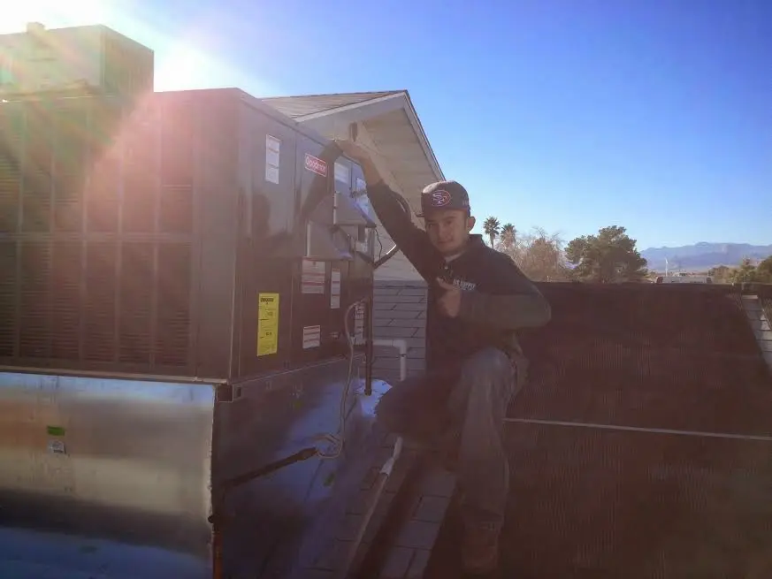 HVAC technician performing Air Duct Repair on a rooftop unit in Crooked River Ranch